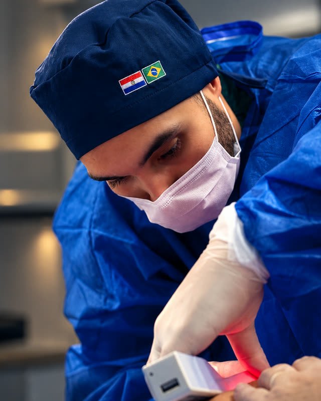 Dr. Jonatas Carvalho aplicando o tratamento, com o gorro do Paraguai e do Brasil